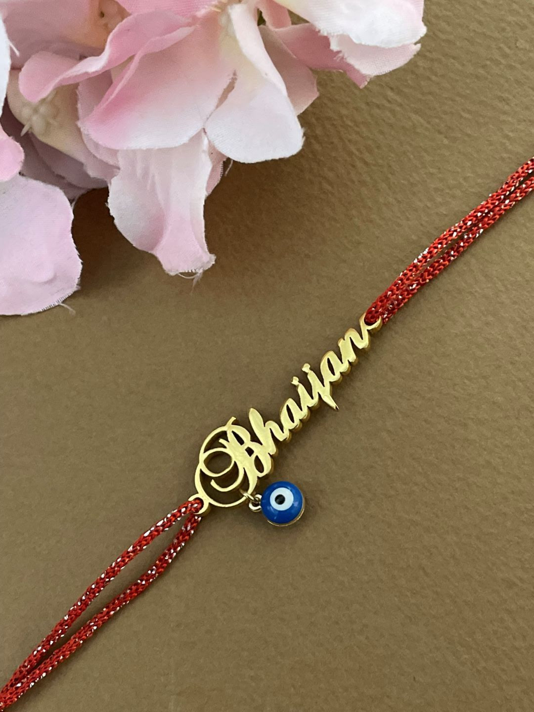 Customized Gold Plated Name Rakhi Pendant With Red Thread and Blue Evil Eye